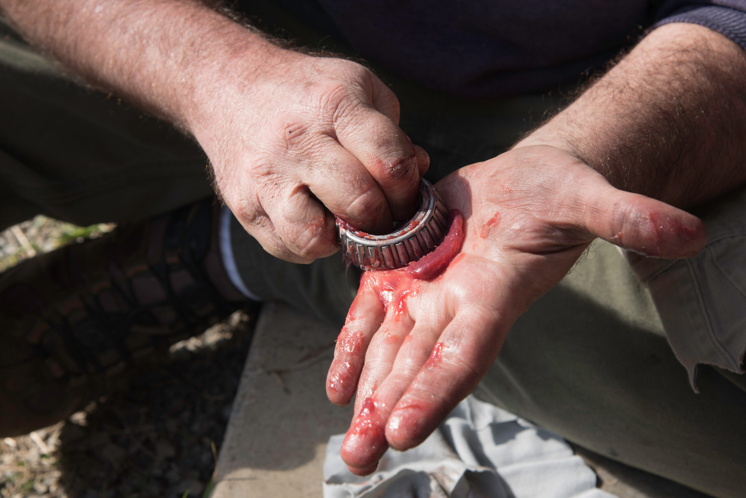 Male hands packing grease into a wheel bearing.